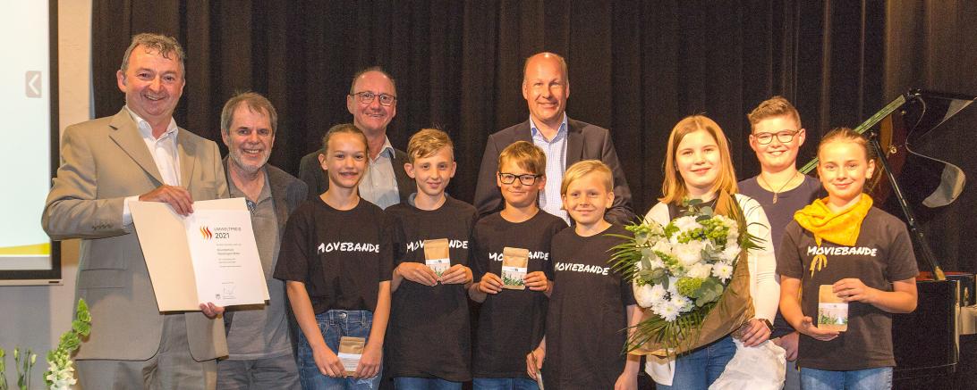 Die Filmgruppe „Moviebande“ der Grundschule Nördlingen-Mitte erhält den Umweltpreis in der Kategorie „Engagement von Schulklassen“ von Bezirkstagspräsident Martin Sailer (hinten rechts) und Bezirksrat Albert Riedelsheimer (1. von links). 