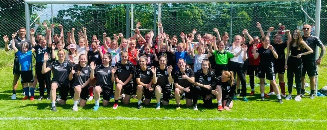 Zu sehen sind eine Gruppe Mädchen vor einem Fußballtor. 