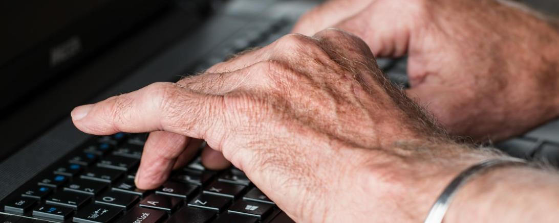 Das Bild zeigt einen Mann an einem Laptop.