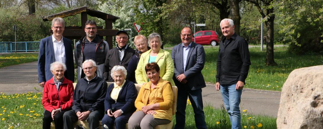 Das Bild zeigt Personen die auf der neuen Ruhebank in Munningen sitzen.