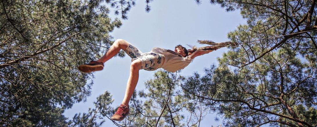 Das Bild zeigt ein Kind an einem Seil.