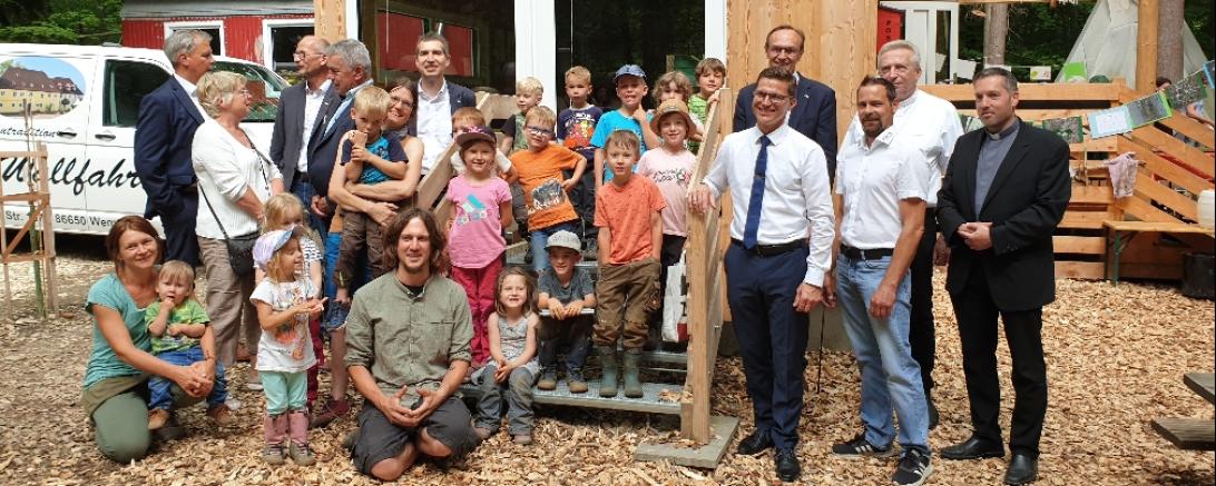 Zu sehen sind Erwachsene und Kinder vor dem Waldkindergarten an der Alten Bürg. 