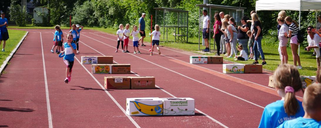 Kinder bei Hürdenstaffel. 