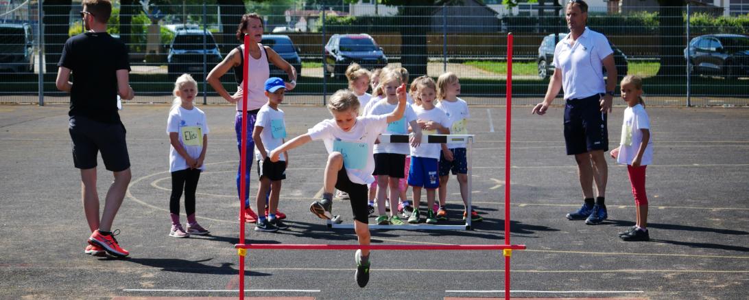 Kinder beim Hoch-Weitsprung. 