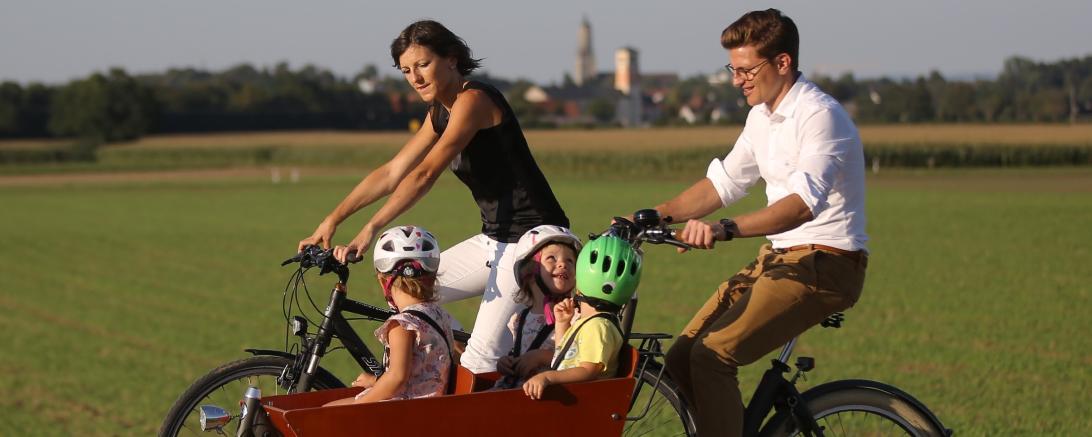 Das Bild zeigt eine Familie beim Radfahren.