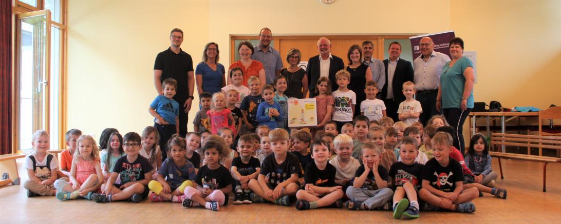 Die Kindergartenkindern freuen sich zusammen mit Leiterin Gabi Litzel-Reißler, ihrem Team, Vertretern des Elternbeirates, der Stadt Donauwörth, dem LEW-Kommunalmanager Michael Smischek und der stellvertretenden Landrätin Claudia Marb über das Entdecker-Paket. 