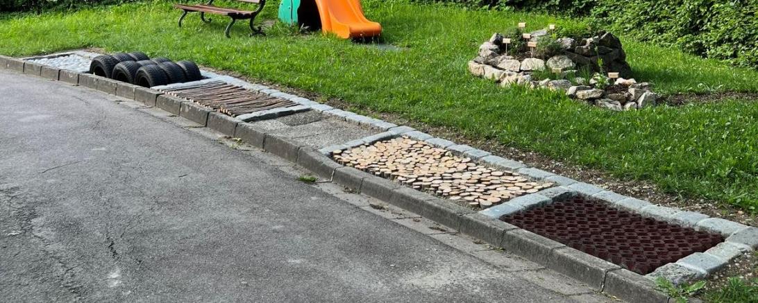 Der Barfußpfad mit der Kräuterschnecke im Hintergrund. 