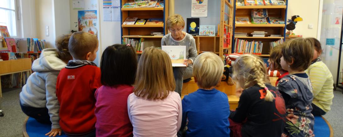 Kinder bei einer Vorlesestunde. 
