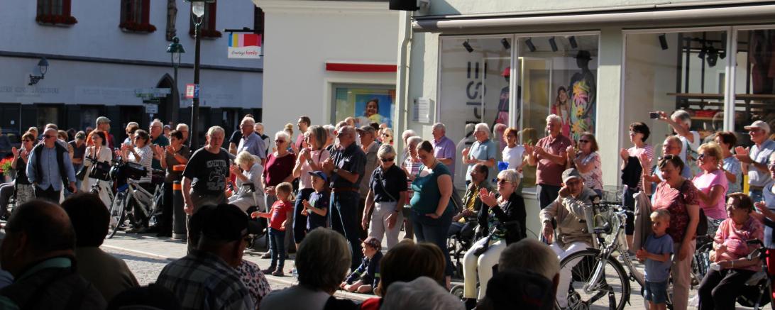 Das Bild zeigt einige Zuschauer*innen bzw. Zuhörer*innen am Marktplatz in Nördlingen