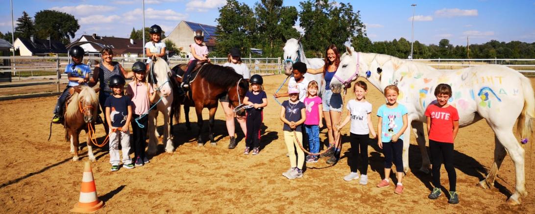 Das Bild zeigt die Kinder des Ferienprogramms der Reitschule Schwabhof zusammen mit den Pferden.