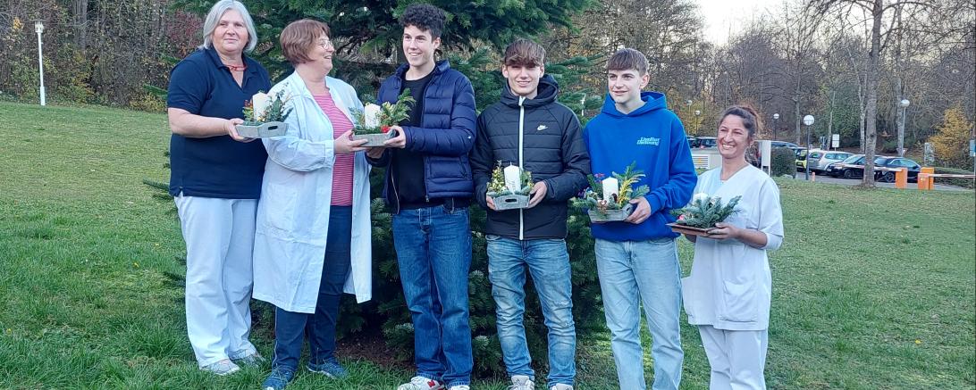 Schüler bei der Übergabe der Gestecke an die Leitung und die Mitarbeiter der Palliativstation.