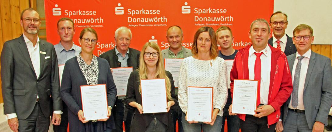 Das Bild zeigt von links Sparkassendirektor Michael Scholz, Dietmar Wegert (Gemeinde Otting), Alexandra Kammer (Rektorin Grundschule Tapfheim), Johann Mair (AWO-Vorsitzender Mertingen), Franziska Wiedemann (Dr.-Hermann-Fendt Kindergarten Asbach-Bäu- menheim), Markus Harsch (Zweiter Bürgermeister Kaisheim), Steffi Dußmann (SV Marxheim), Fabian Seefried (Jugend Belzheim), Roman Leister (Spielvereinigung Herblingen-Hochaltin- gen), Sparkassendirektor Johann Natzer sowie den Vorsitzenden des Stiftungsvorstandes