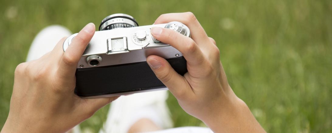 Eine Kamera in den Händen einer Person. 