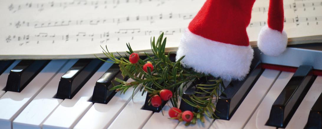 Eine kleine Weihnachtsmütze auf einem Klavier.