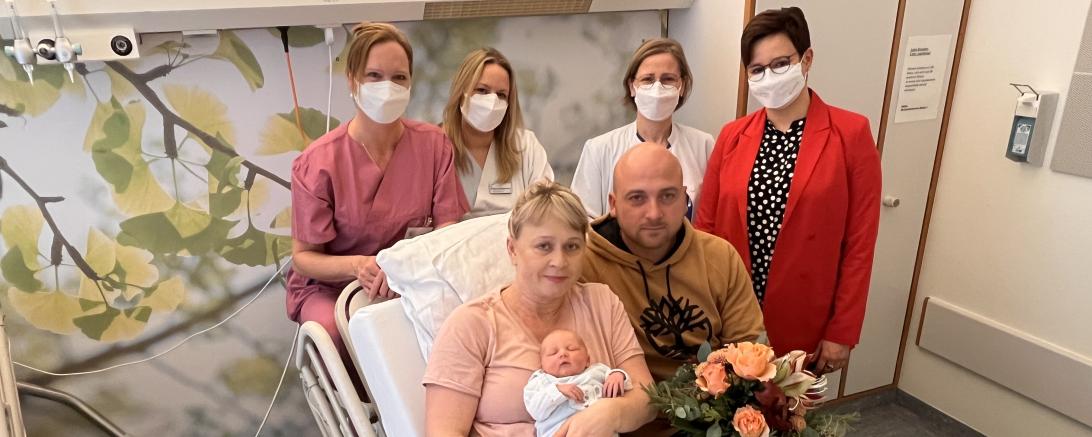 Swetlana und Andreas Anton mit ihrem Sohn Michael. Hebamme Heike Eber, Stationsleiterin Andrea Lechner, Oberärztin Dr. Anne-Kathrin Geisler und Pflegedienstleiterin Michaela Rechner (von links) freuen sich mit den Eltern und überreichten einen Blumenstrauß.