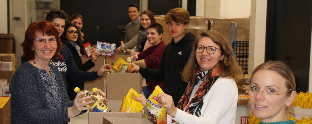 das Bild zeigt Menschen die einpacken