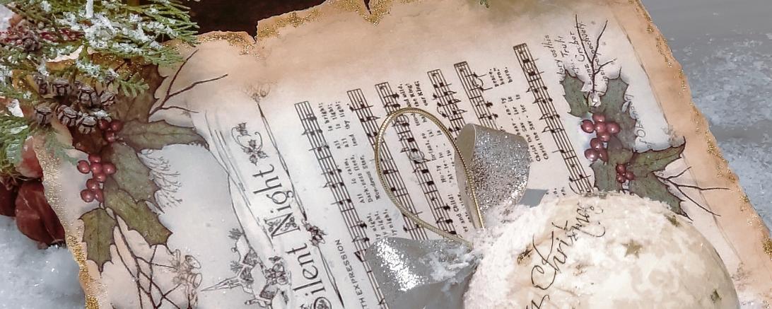 Das Bild zeigt ein Notenblatt mit weihnachtlicher Dekoration.