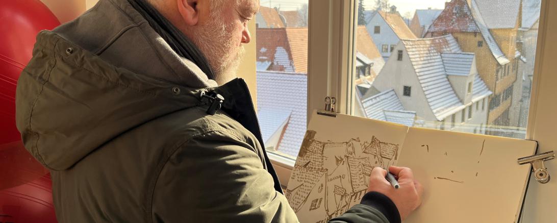 Künstler Alexander Wachtel beim Zeichnen in der Stadtbibliothek.