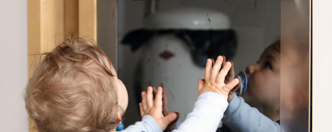 DAs Bild zeigt ein Kleinkind vor dem Backofen.
