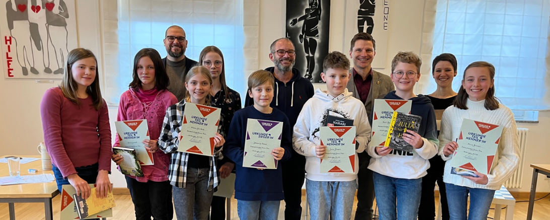 Im Bild sind die Teilnehmer und die Jury des Vorlesewettbewerbs zu sehen.
