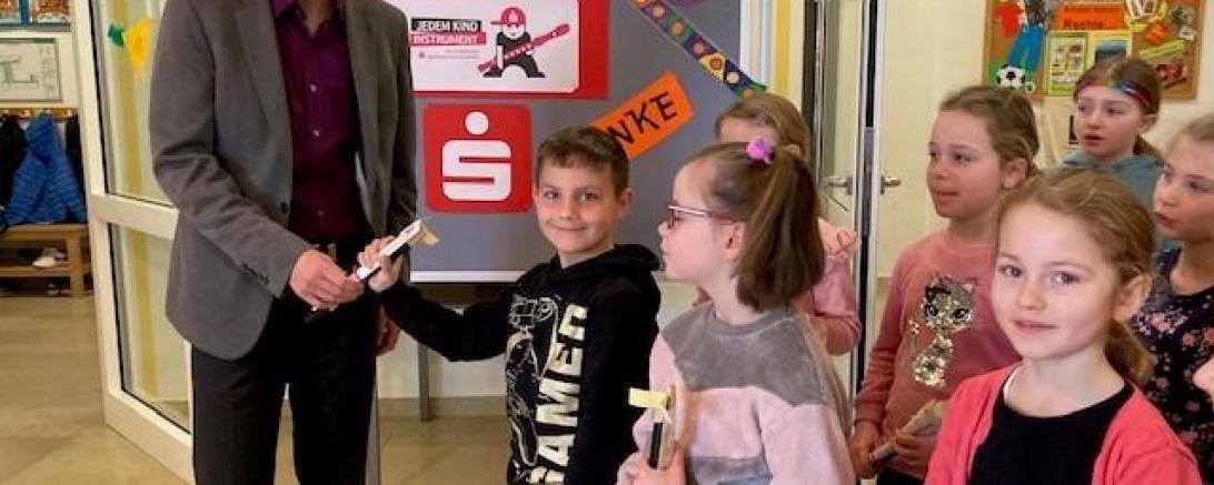 Herr Weiland überreicht jedem Kind eine Flöte.