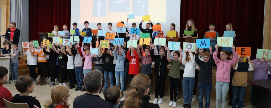Der Unterstufenchor hieß die zahlreichen Gäste herzlich in der Aula willkommen.