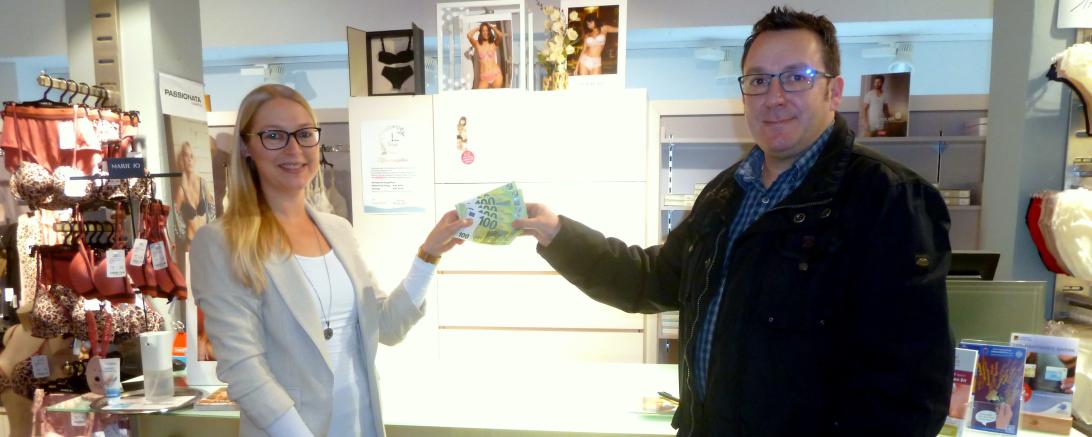 Susanne Böswald (Haus der Wäsche) und Branko Schäpers (Caritasverband) bei der Spendenübergabe.