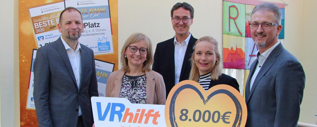 Die beiden Vorstände der VR Bank Neuburg-Rain eG, Bernd Bengel (li.) und Roland Gieß (re.), überreichen zusammen mit dem Regionalleiter Wolfgang Schlicker den symbolischen Scheck an Hedwig Rehm und Julia Schmalbach vom Helferkreis Rain.