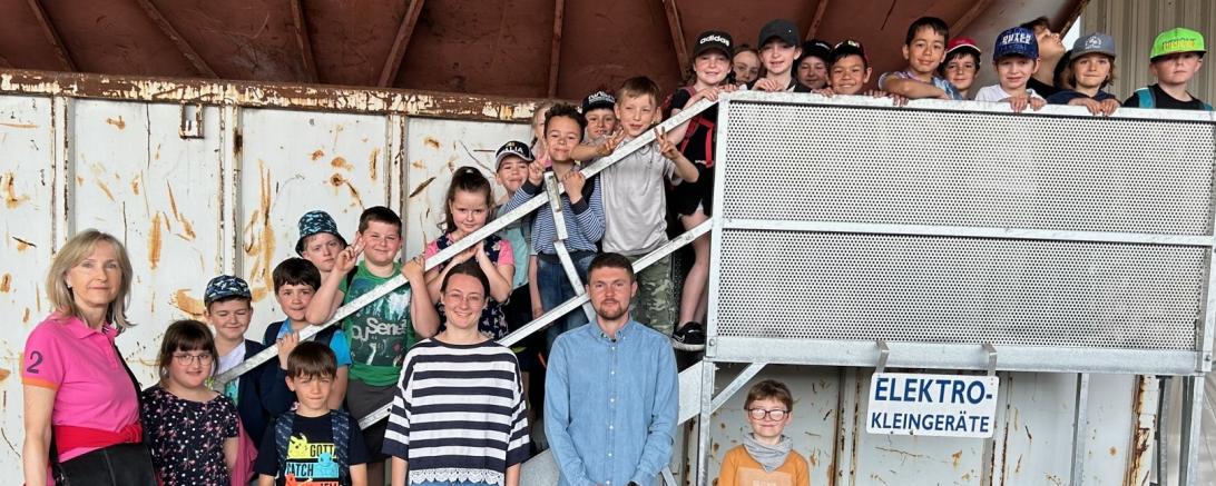 Auf dem Foto sind die Klasse 2b mit ihrer Klassleiterin, Frau Martina Schmid, sowie Frau Emma Christa und Herrn Fabian Weißenburger vom AWV Nordschwaben zu sehen.