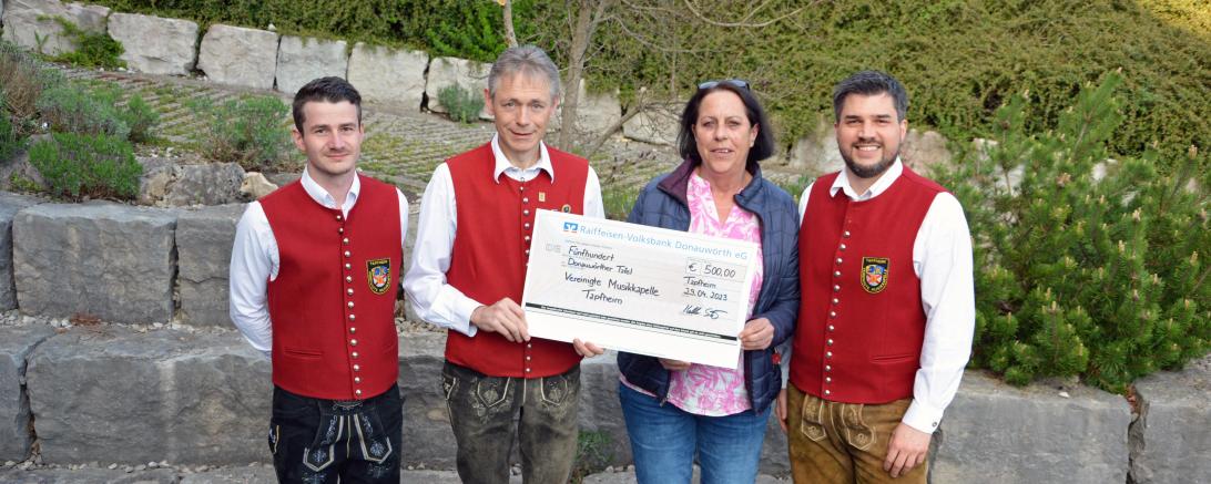 Der erste Vorsitzende der VMT, Stefan Keller (Mitte) übergibt den Spendenscheck gemeinsam mit den zweiten Vorsitzenden Markus Stadlmayr (links) und Michael Stadlmayr (rechts) an Andrea Strobel von der Tafel Donauwörth.