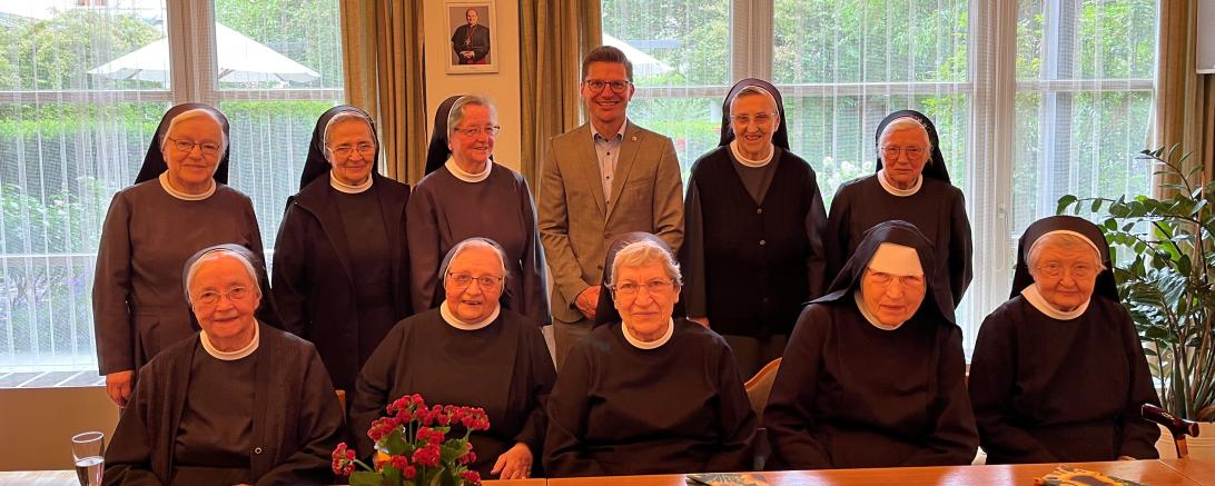 Oberbürgermeister David Wittner gratuliert Sr. Adelhilde (beide Mitte hinten) zum runden Geburtstag. 