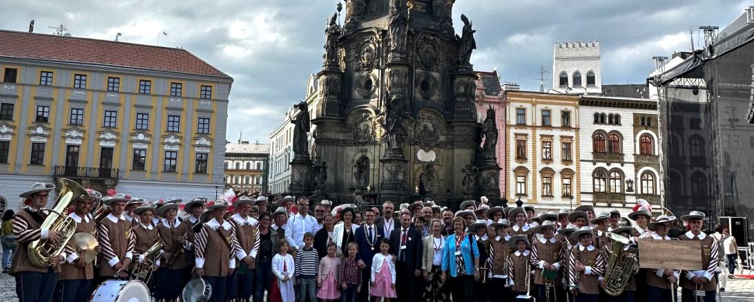 Die offizielle Delegation, angeführt von Oberbürgermeister David Wittner mit der Knabenkapelle Nördlingen vor der Dreifaltigkeitssäule (UNESCO-Weltkulturerbe) auf dem Marktplatz der Partnerstadt Olomouc.