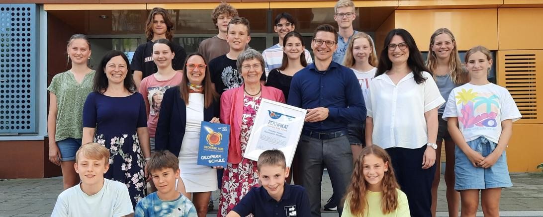 Zweite Reihe v. l. n. r.: StRin Daniela Vogler, Heike Burkhardt (Geschäftsführerin Geopark Ries e. V.), Schulleiterin Dr. Renate Rachidi, Oberbürgermeister David Wittner, OStRin Heike Hauck sowie die Schülersprecher (letzte Reihe) und einige Klassensprecherinnen und Klassensprecher.