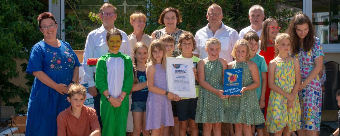 Die Grundschule Mönchsdeggingen wird Geopark Ries-Schule. Hintere Reihe: Rektorin Katja Ruf-Lettenmeier, Landrat Stefan Rößle (1. Vorsitzender Geopark Ries e.V.), Konrektorin Annett Schäfer, Bürgermeisterin Karin Bergdolt (1. Vorsitzende des Schulverbands Mönchsdeggingen), Bürgermeister Timo Böllmann, Bürgermeister Armin Sporys, Heike Burkhardt (Geschäftsführerin Geopark Ries e.V.) und Ramona Ruf (Internationales, Geopark Ries e.V.)