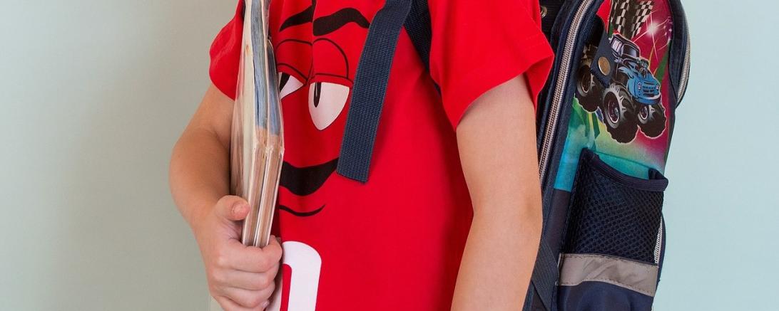 Das Bild zeigt einen Jungen mit Schulranzen. 