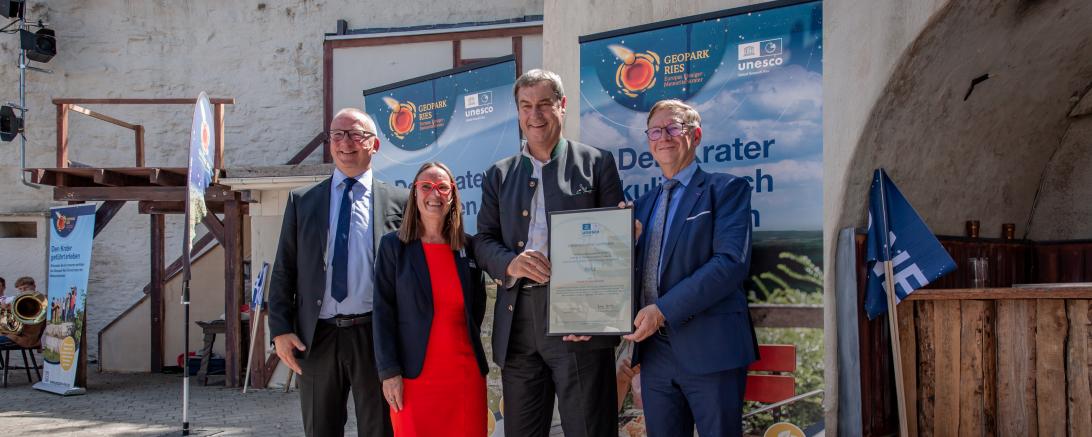 Das Bild zeigt (von links) Dr. Lutz Möller (stellvertretender Generalsekretär der Deutschen Unesco-Kommission), Heike Burkhardt (Geschäftsführerin Geopark Ries e.V.), Ministerpräsident Markus Söder und Landrat Stefan Rößle.