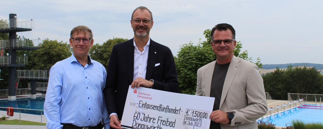 Geburtstagsgeschenk ans Freibad: Michael Scholz (Sparkasse Donauwörth) übergibt mit Landrat Stefan Rößle einen Spendenschek an OB Jürgen Sorré. 