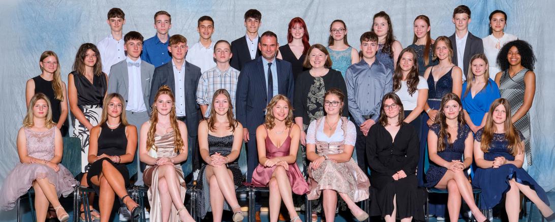 Die stellvertretende Landrätin Claudia Marb und Schulleiter Christian Sattich gratulieren 29 Absolvent*innen der Realschule Rain zum Realschulabschluss mit der Note 1 vor dem Komma, ganz besonders der Schulbesten Felicitas Moll (vorne Mitte) zum Traumschnitt von 1,0.