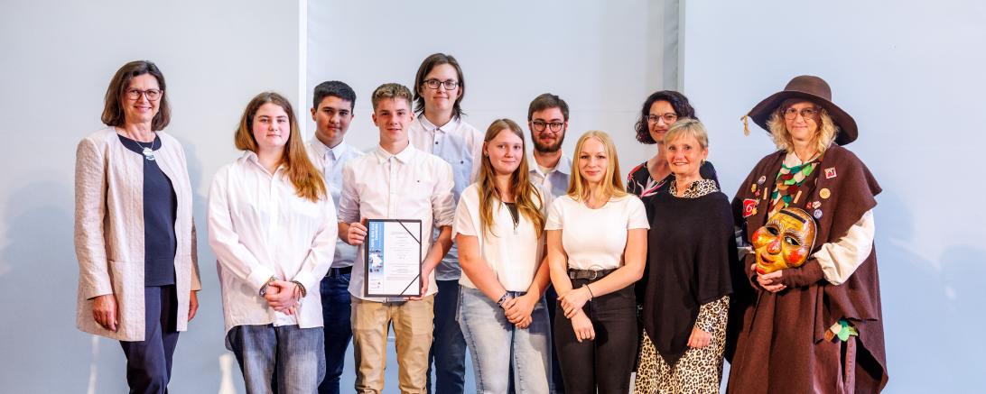 Landtagspräsidentin Ilse Aigner, Schülerinnen und Schüler der WiK-Gruppe der Klasse 10bM, Lehrerin Kerstin Huber, Rektorin Margit Stimpfle, als ‚Huaderle‘ Volkskundlerin Eva Uhl