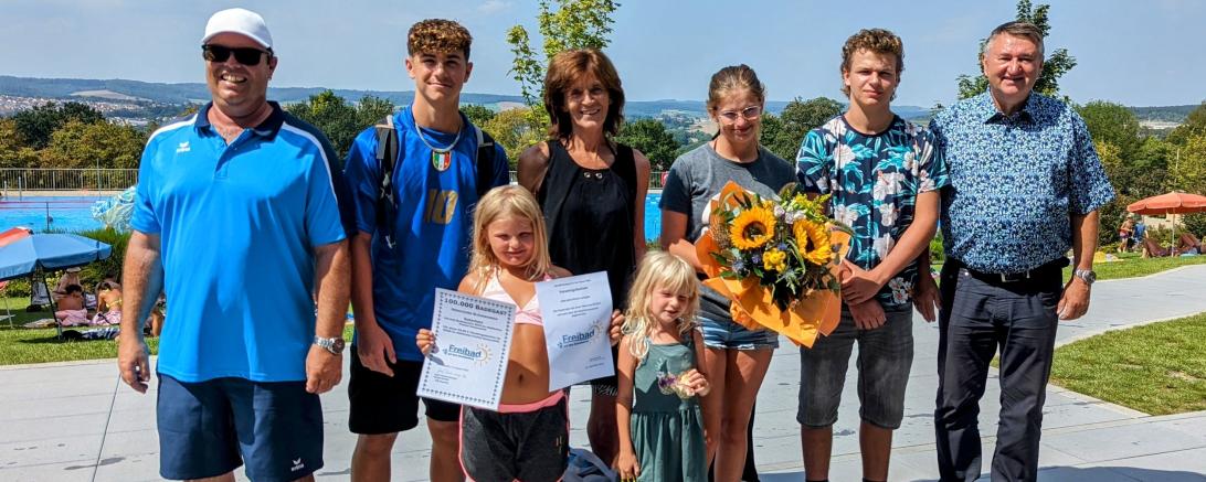 Petra Schubert-Schmid (Mitte) war Badegast Nummer 100 000 im Donauwörther Freibad. Gemeinsam mit ihren Enkeln Marcel, Aleyna, Mia und Jenny sowie deren Freund Leon freut sie sich nun über Saisonkarten für 2024 sowie einen Verzehrgutschein fürs Freibad-Kiosk. Die Gutscheine übergaben Bürgermeister Josef Reichensberger (ganz rechts im Bild) und Bäder-Betriebsleiter Robert Blaschek (ganz links im Bild). 