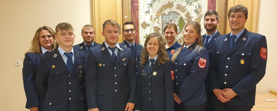 V.l.: Natalie Amslinger (Vertrauensperson), Jan Lindenmeyer (Beisitzer – Helfer), Jochen Zimmerer (Gruppenführer und Atemschutzbeauftragter), Mark Lindenmeyer (Vertrauensperson), Alexander Loacher (Beisitzer – Gerätewart), Marie Engelhardt (Kassier), Johanna Beck (Zweite Kommandantin und Schriftführerin), Sophia Piechatschek (Erste Vorsitzende), Daniel Glaß (Zweiter Vorsitzender), Klaus Röttinger (Erster Kommandant). Nicht im Bild: Sofia Weisbeck (Gruppenführerin und Kinderfeuerwehrbeautragte), Carmen Lechn
