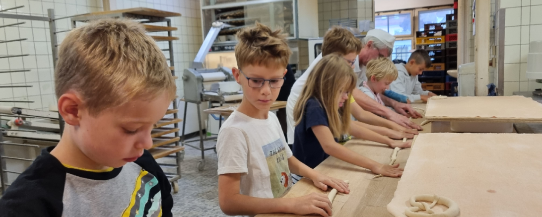 Das Bild zeigt die Kinder beim formen der Brezen