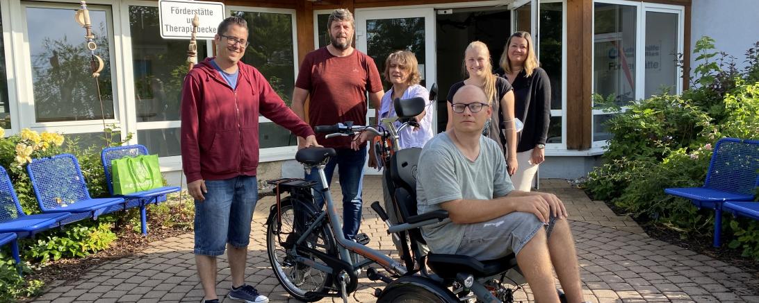 Das Bild zeigt das Team der Förderstätte mit einer der der neuen Rikschas.