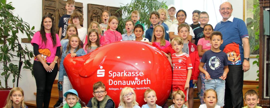 Das Bild zeigt die Feriengäste mit (links) Dodo (Alina Schmidt) und (rechts) Didi (Thomas Deuter) vom KNAX-Klub der Sparkasse Donauwörth, die das Programm gestalteten.