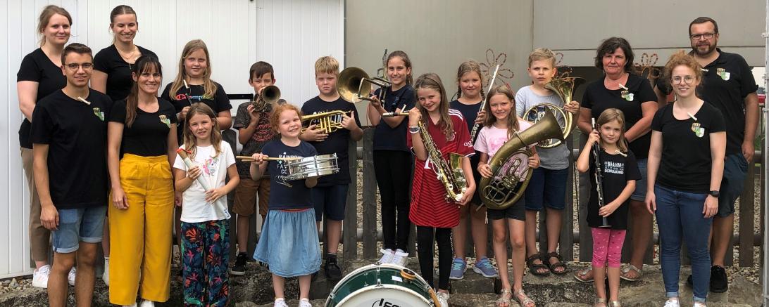 Das Bild zeigt die teilnehmenden Kinder des Ferienprogrammes zusammen mit den Jugendleitern und weiteren Musikerinnen und Musikern der Stadtkapelle Harburg.