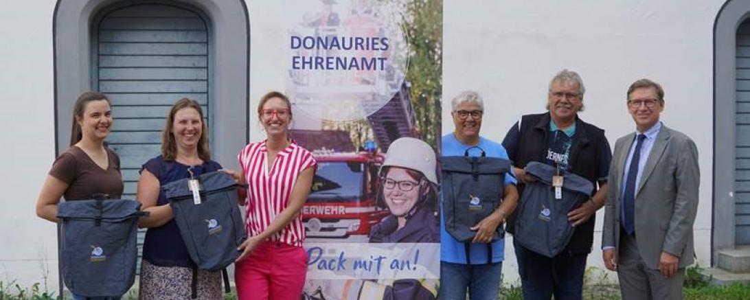 Landrat Stefan Rößle und Ehrenamtsbeauftragte Karin Brechenmacher überreichen die Ehrenamts-Rucksäcke an die Gewinner der Ehrenamts-Post-Verlosung.