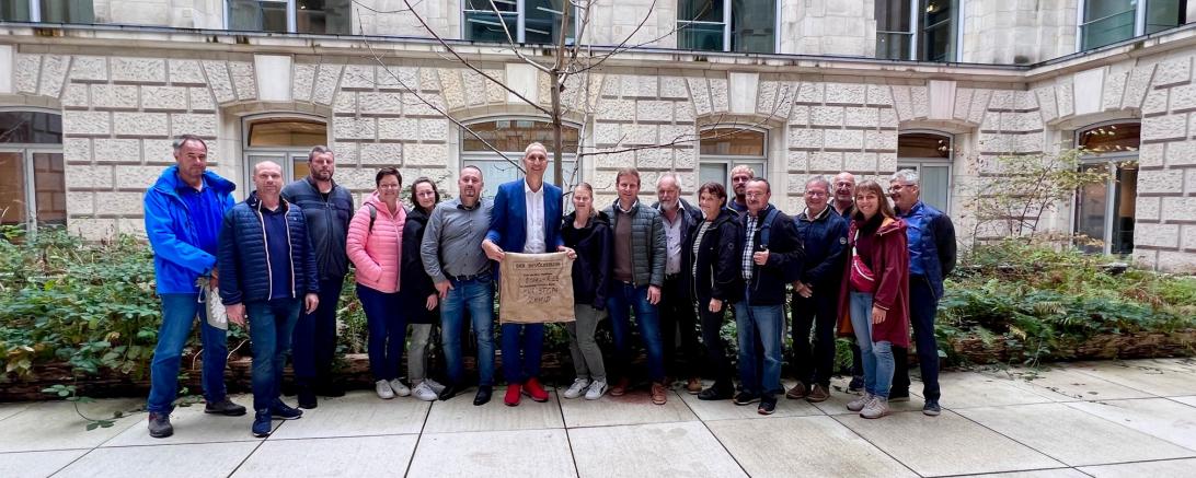 Zusammen mit dem Gemeinderat von Alerheim bringt MdB Christoph Schmid Erde aus dem Wahlkreis in Berliner Kunstwerk ein.