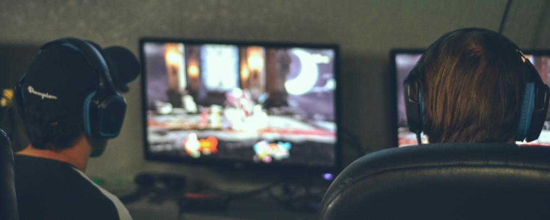 Das Bild zeigt zwei Personen vor einem PC.