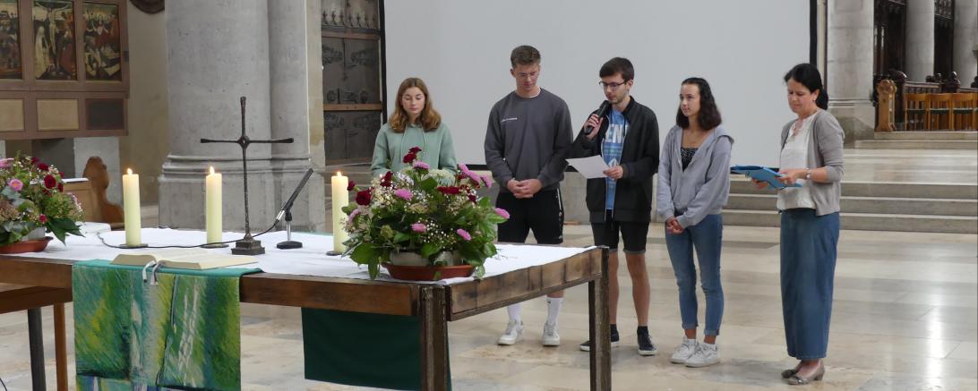 Es gestalteten auch etliche Schülerinnen und Schüler den ökumenischen Schuljahresanfangsgottesdienst mit. Im Bild sind Mitglieder der Q12 und Susanne Schmid zu sehen.