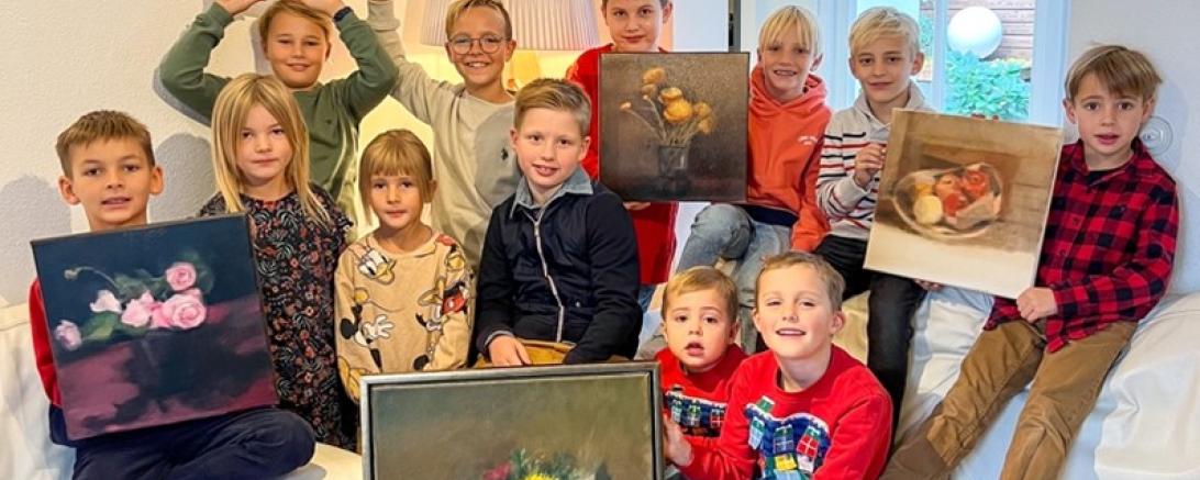 Das Bild zeigt die Kinder der Lionsclub-Mitglieder mit den zu versteigernden Werken Ruißings.